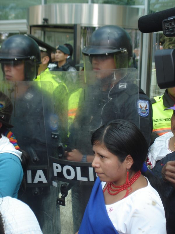 Foto von indigenen Aktivistinnen umgeben von Polizisten in Ecuador.