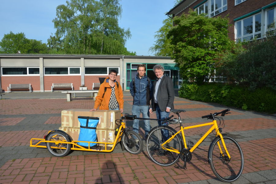 Laura Hebling übergibt für Vamos e.V. die Ausstellung an Schulleiter Christian Schrand und den Schüler Luca Thomas.