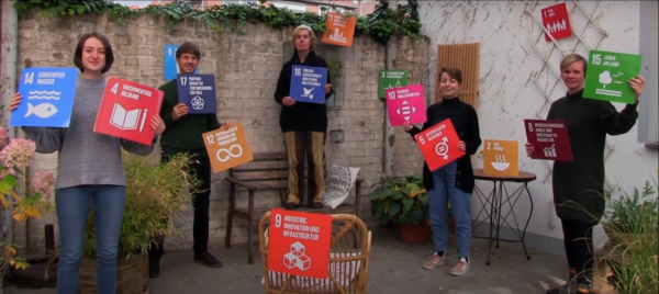 5 Personen halten Plakate der SDGs hoch.