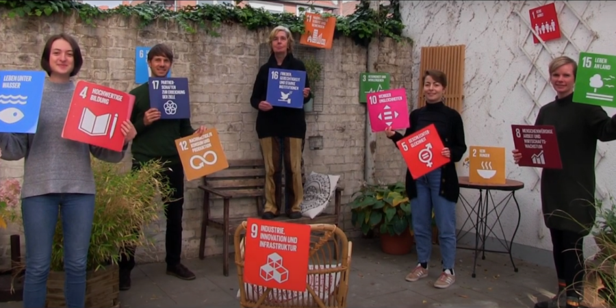 5 Personen halten Plakate der SDGs hoch.
