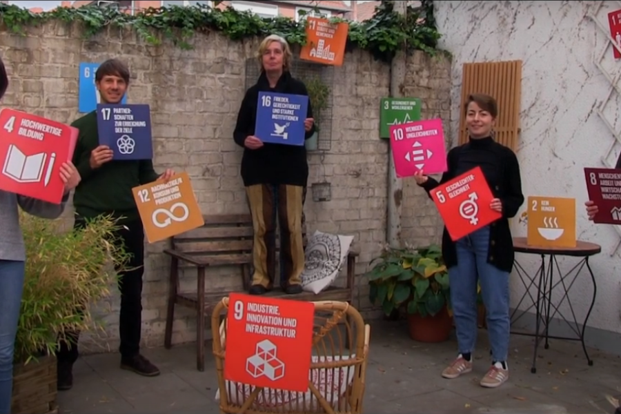 5 Personen halten Plakate der SDGs hoch.