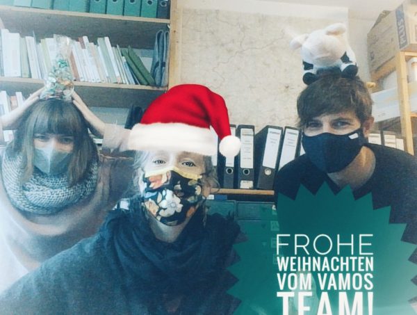 Drei Menschen mit Weihnachtsmütze wünschen frohe Weihnachten