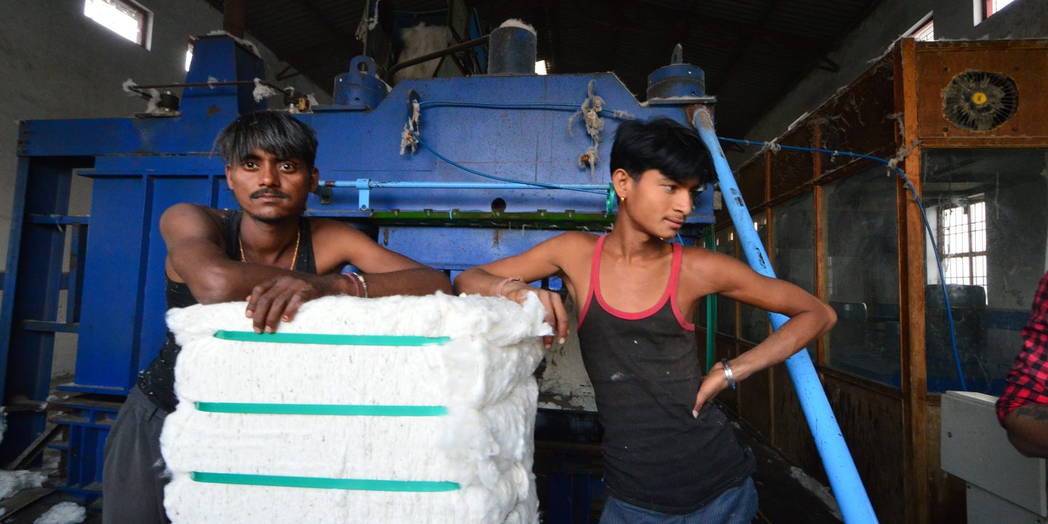 Pressemitteilung nachhaltiger Textileinkauf zwei junge Arbeiter in einer Fabrik