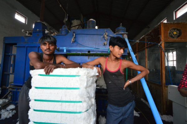 Pressemitteilung nachhaltiger Textileinkauf zwei junge Arbeiter in einer Fabrik