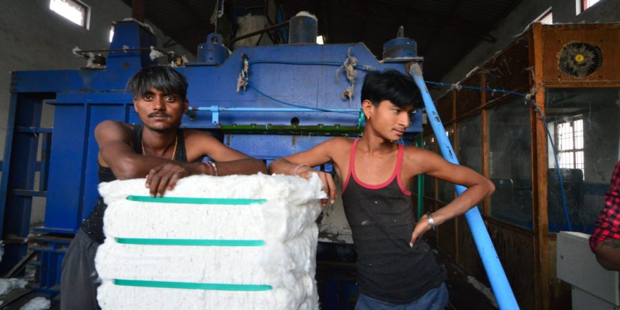 Pressemitteilung nachhaltiger Textileinkauf zwei junge Arbeiter in einer Fabrik