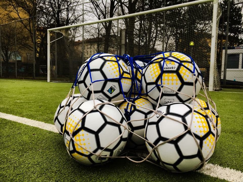 Fußballbälle in einem Netz vor einem Fußballtor