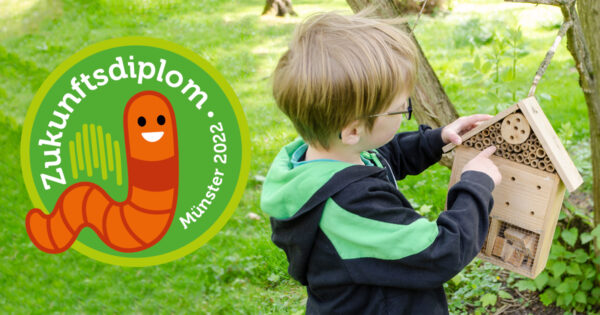 Ein Kind hat ein Insektenhotel in der Hand