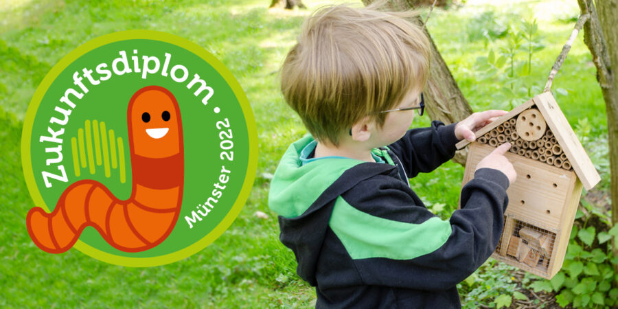 Ein Kind hat ein Insektenhotel in der Hand