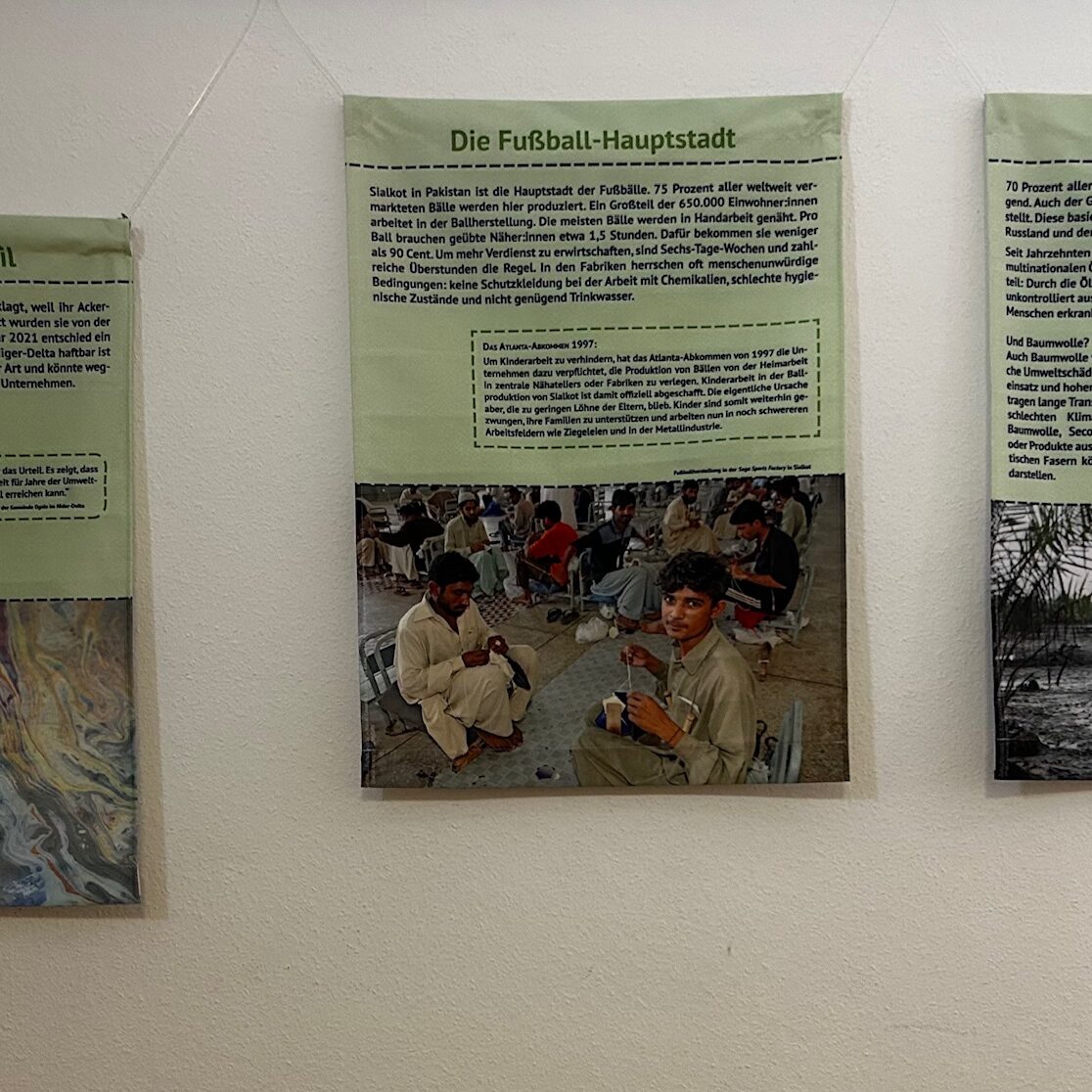Mehrere Stoffbanner der Ausstellung hängen an der Wand
