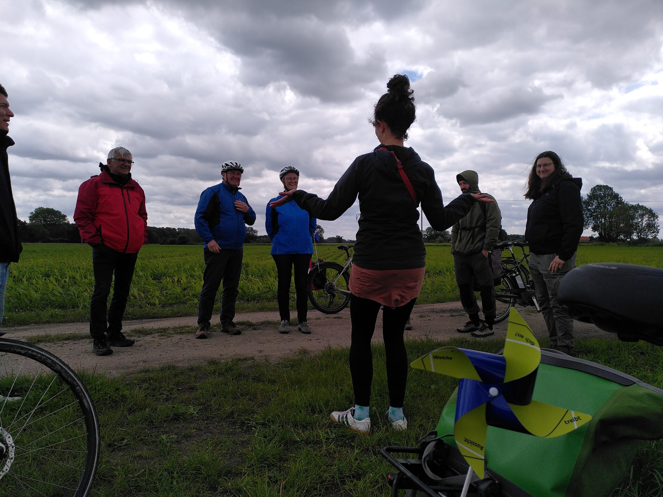 Frau erklärt Gruppe etwas am Feldrand