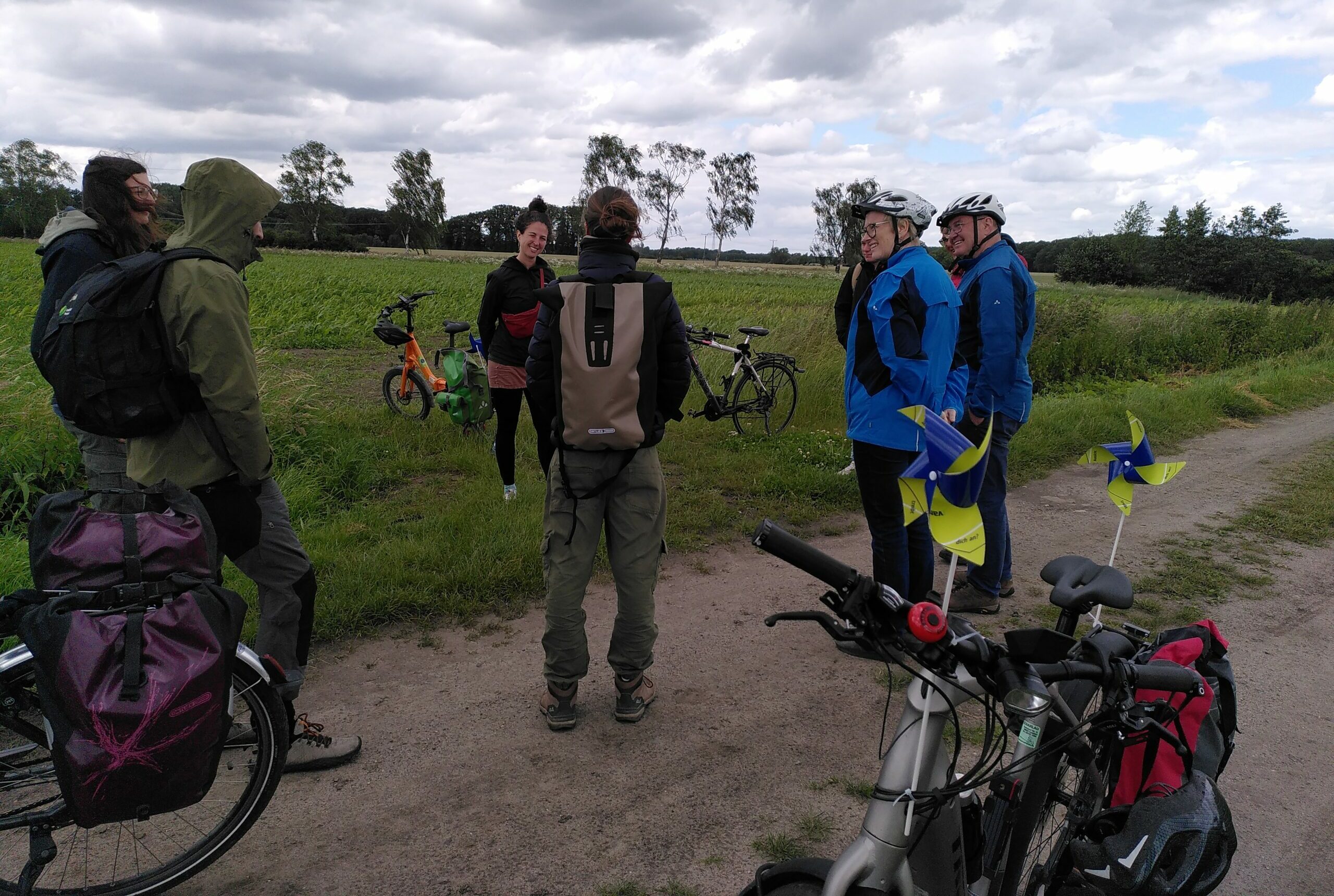 Gruppe steht im Kreis auf Feldweg